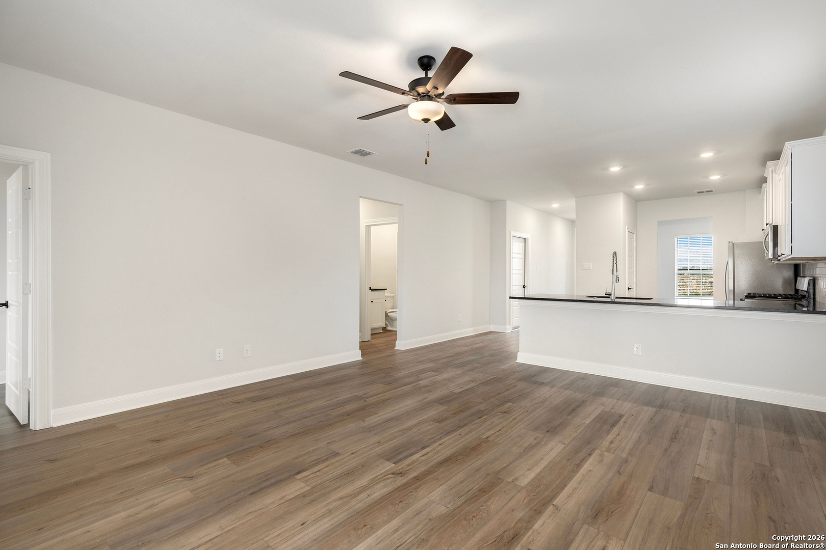 6311 Monk Landing Converse, TX 78109 - Photo 5 of 16 a view of an empty room and kitchen view with wooden floor