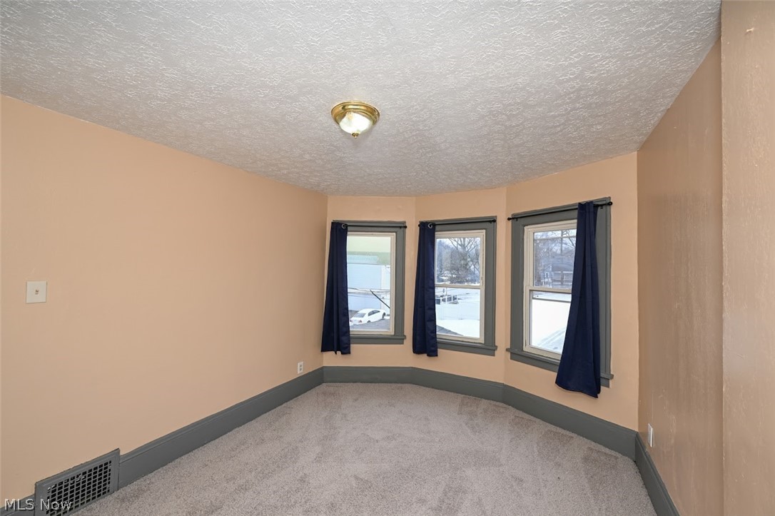 77 West Mildred Avenue Akron, OH 44310 - Photo 27 of 40 Carpeted spare room featuring a textured ceiling and baseboards