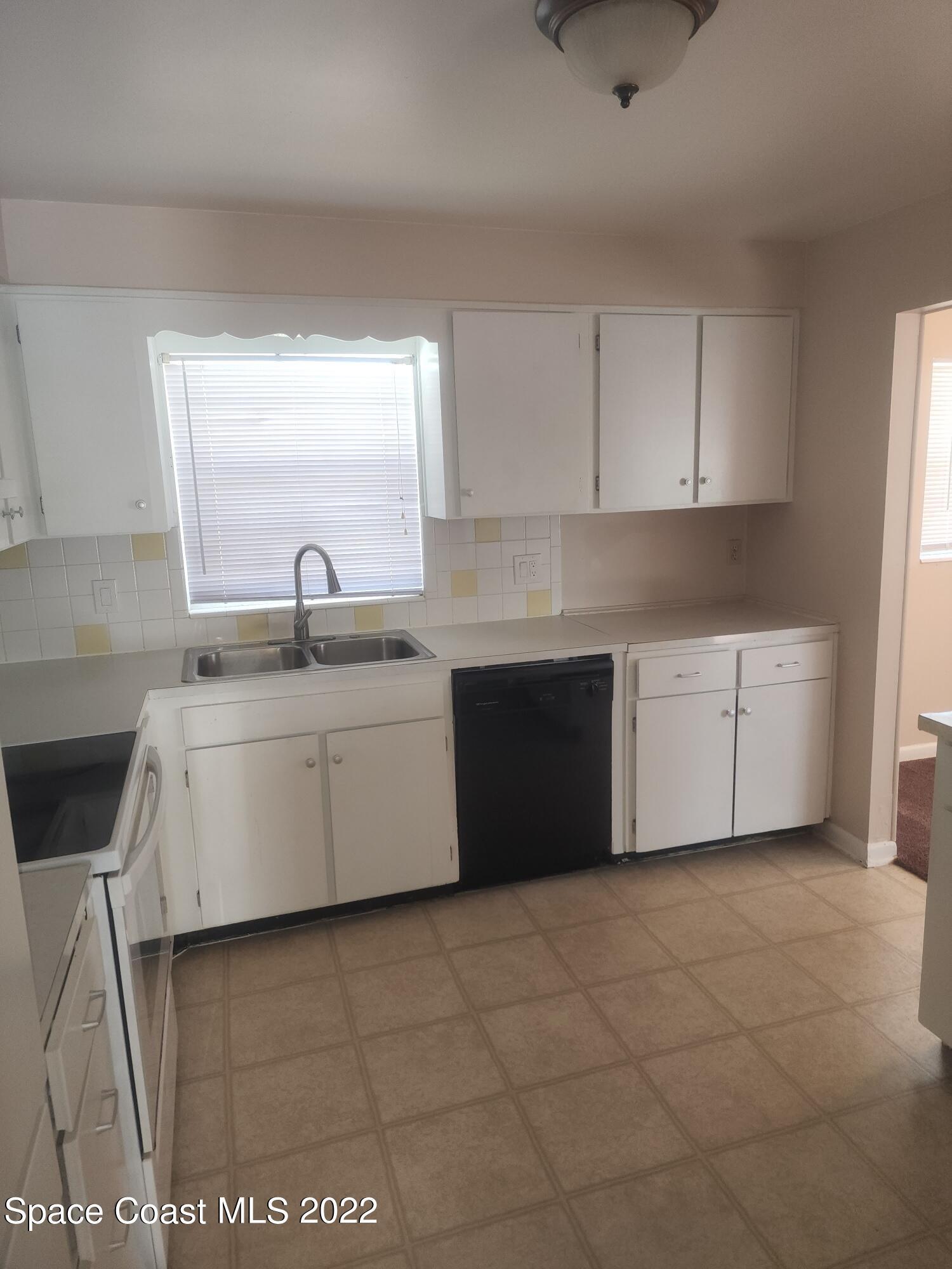 595 Albatross Street Merritt Island, FL 32952 - Photo 13 of 21 a kitchen with a sink cabinets and window