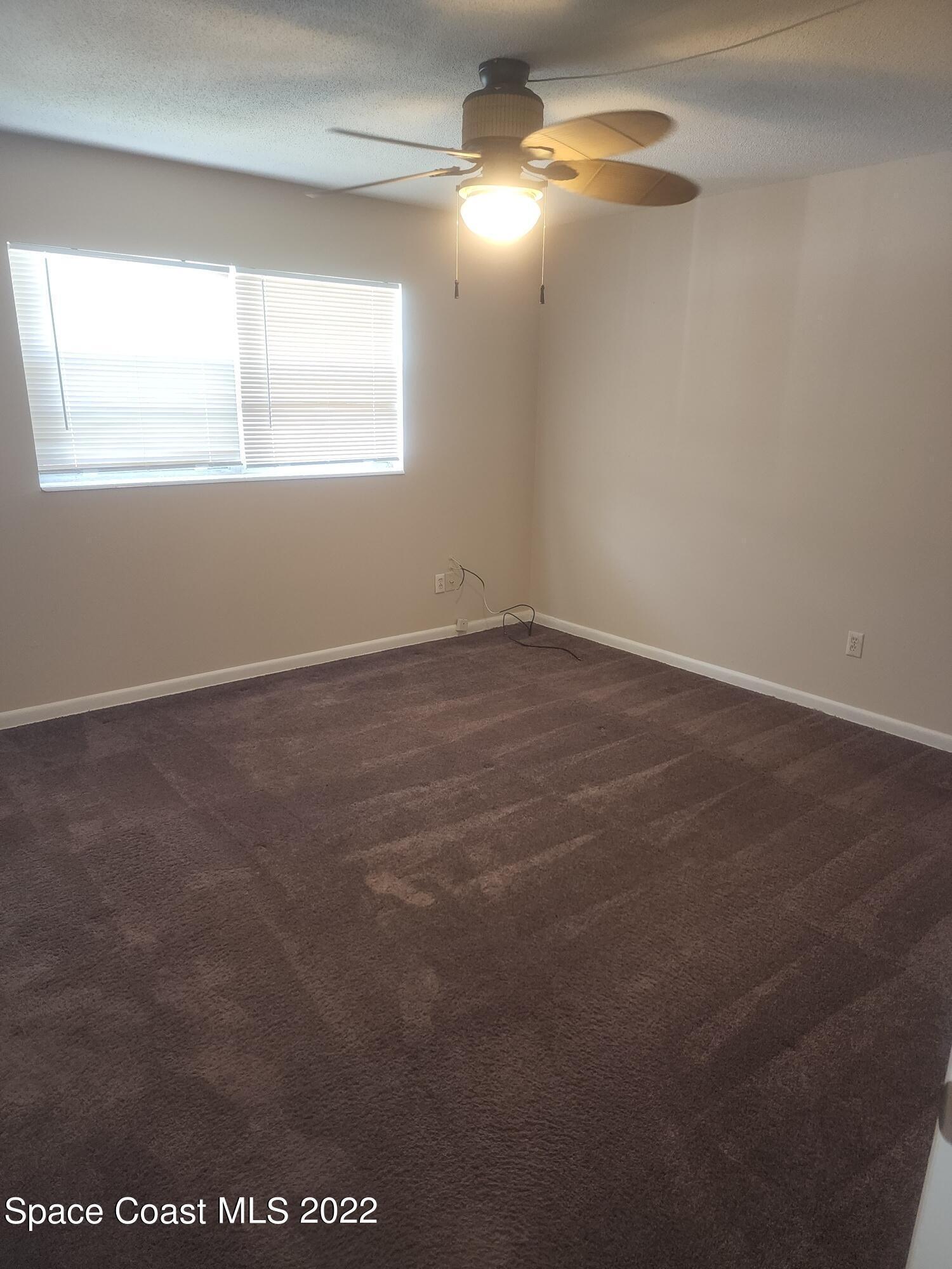 595 Albatross Street Merritt Island, FL 32952 - Photo 15 of 21 an empty room with windows and fan