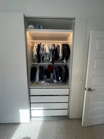 a view of walk in closet with clothes and shoes