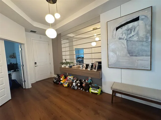 a view of a room with gym equipment and wooden floor
