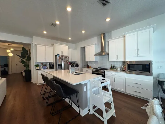 a kitchen with a table chairs refrigerator and cabinets