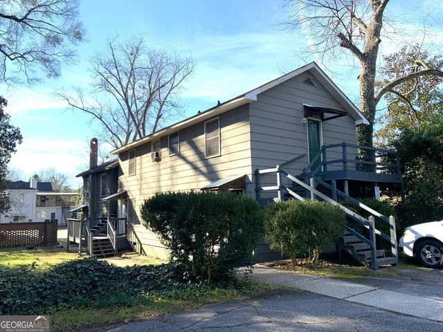 a view of a house with a patio and a yard