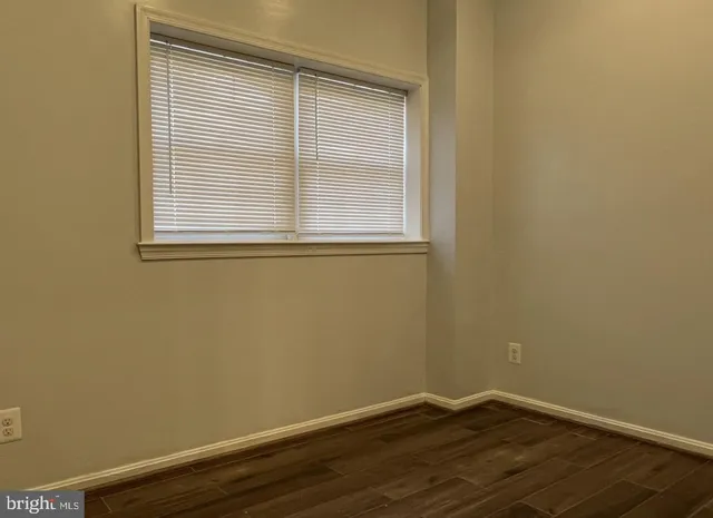 a view of a small space with wooden floor and a window