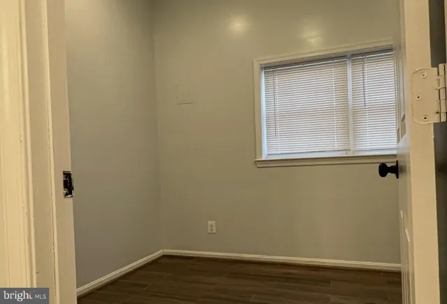 a view of a small space with wooden floor and a window