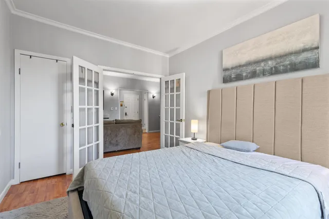 a bedroom with a large bed and wooden floor