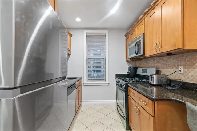 a kitchen with stainless steel appliances granite countertop a sink a stove and a refrigerator