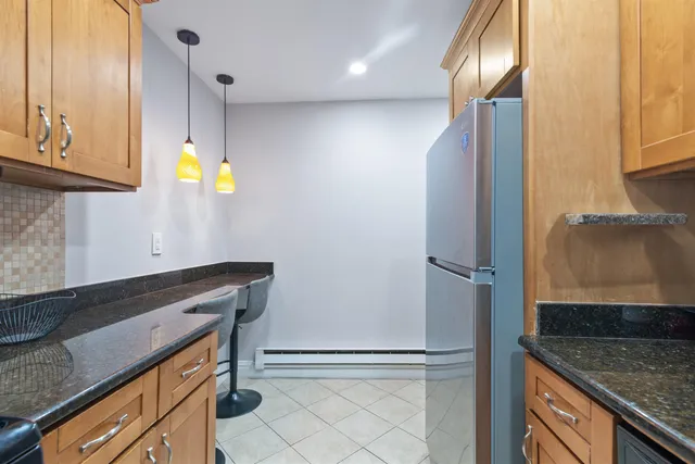 a kitchen with stainless steel appliances granite countertop a sink and a refrigerator