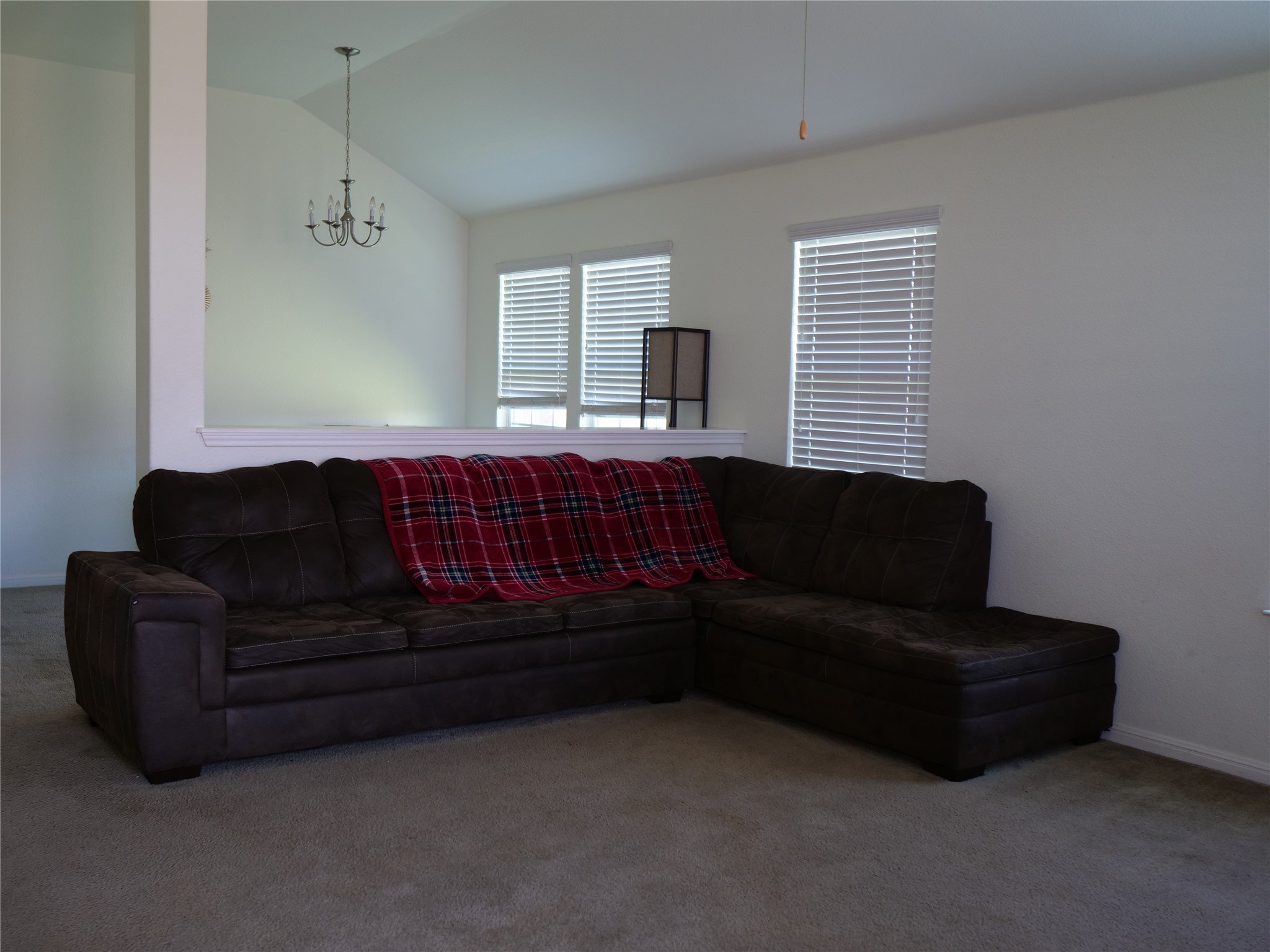 Undisclosed Address Elgin, TX 78621 - Photo 7 of 19 Carpeted living room with vaulted ceiling and suspended lighting