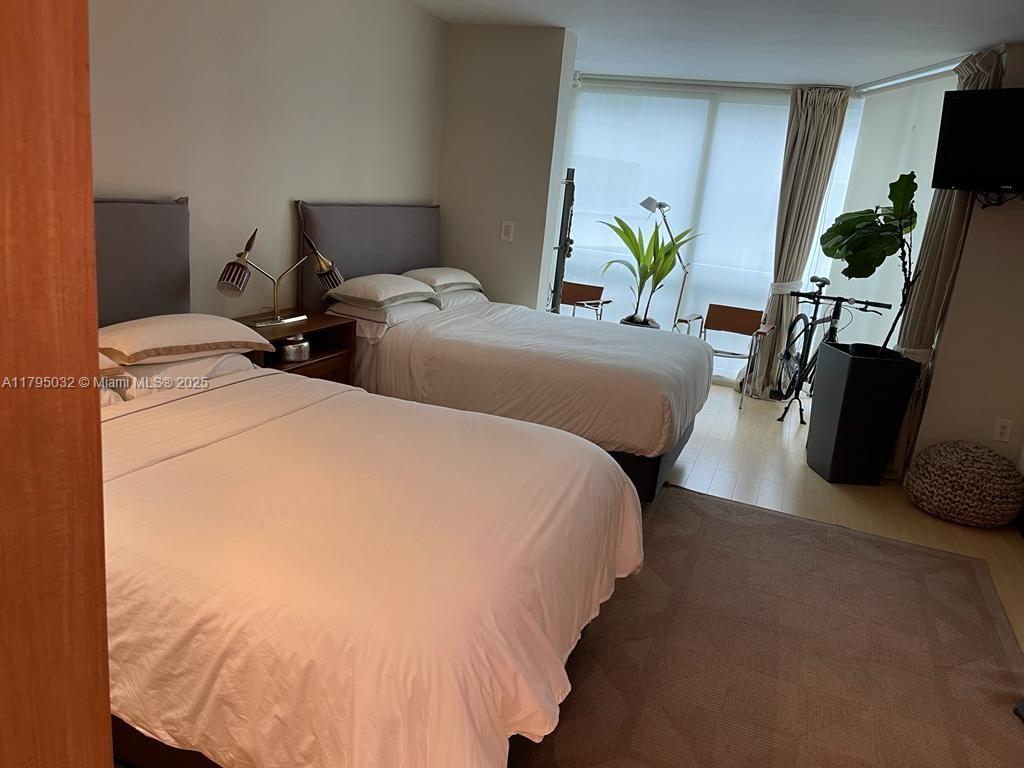 600 Grapetree Drive, Unit 7CS Key Biscayne, FL 33149 - Photo 12 of 19 a bed room with two bed and a potted plant