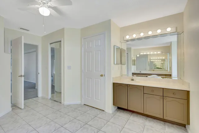 an empty room with windows and ceiling fan