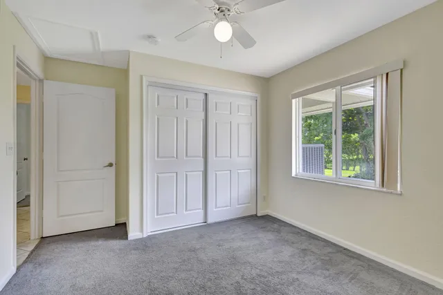 an empty room with windows and closet area