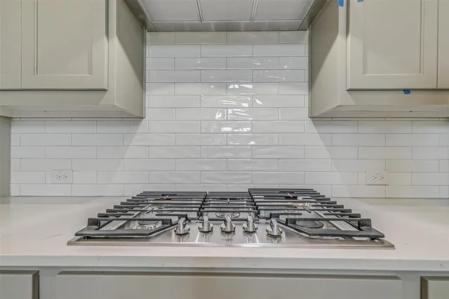 a large kitchen with cabinets wooden floor and stainless steel appliances