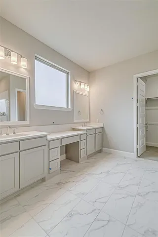 a spacious bathroom with a granite countertop sink a mirror and a bathtub
