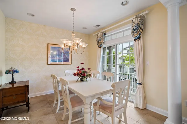 a dining room with furniture a rug and a potted plant