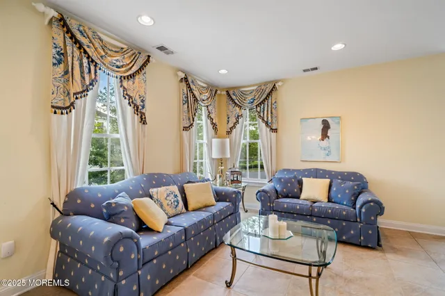 a living room with furniture fireplace and a large window