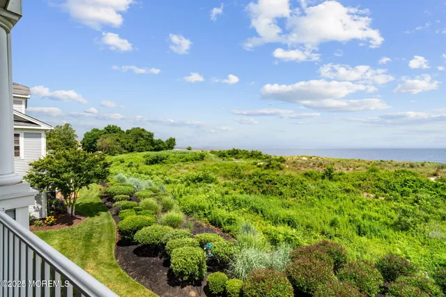 a view of road with card parked on side and retail shops