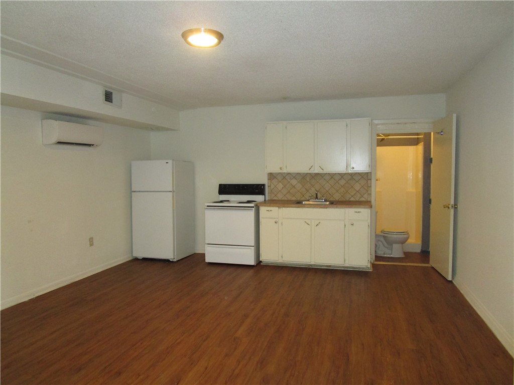 4709 Harmon Avenue, Unit 322 Austin, TX 78751 - Photo 4 of 8 a kitchen with granite countertop a sink and refrigerator