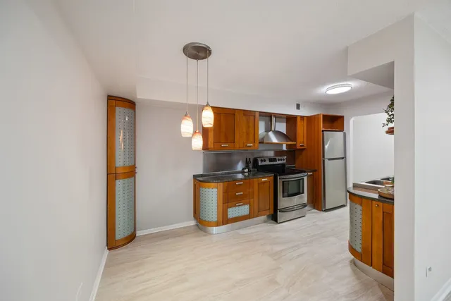 a kitchen with stainless steel appliances granite countertop a refrigerator and a sink