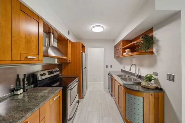 a kitchen with stainless steel appliances granite countertop a stove a sink and a refrigerator