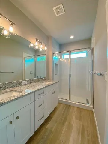 a bathroom with a double vanity sink and mirror