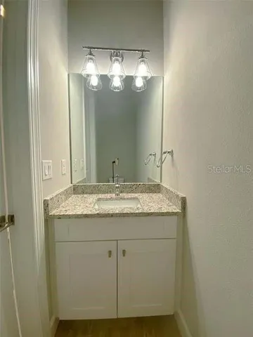a bathroom with a granite countertop sink and a mirror