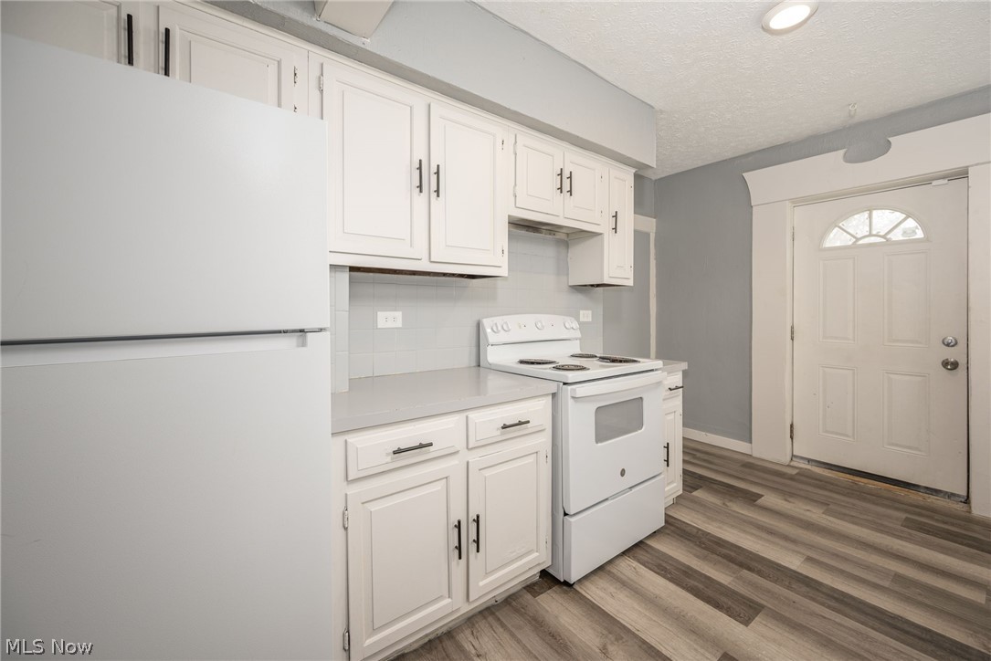1603 Hampton Road Akron, OH 44305 - Photo 14 of 50 Kitchen featuring white appliances, light countertops, white cabinetry, light wood-style flooring, and a textured ceiling