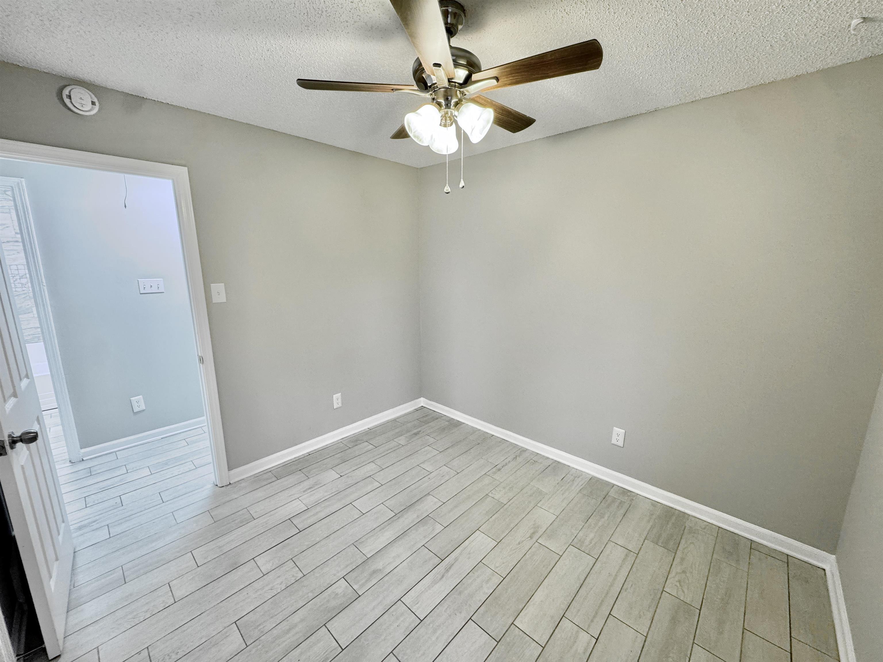 6400 Kerrville Rosemark Road Millington, TN 38053 - Photo 22 of 36 Empty room with a textured ceiling, wood finish floors, and a ceiling fan