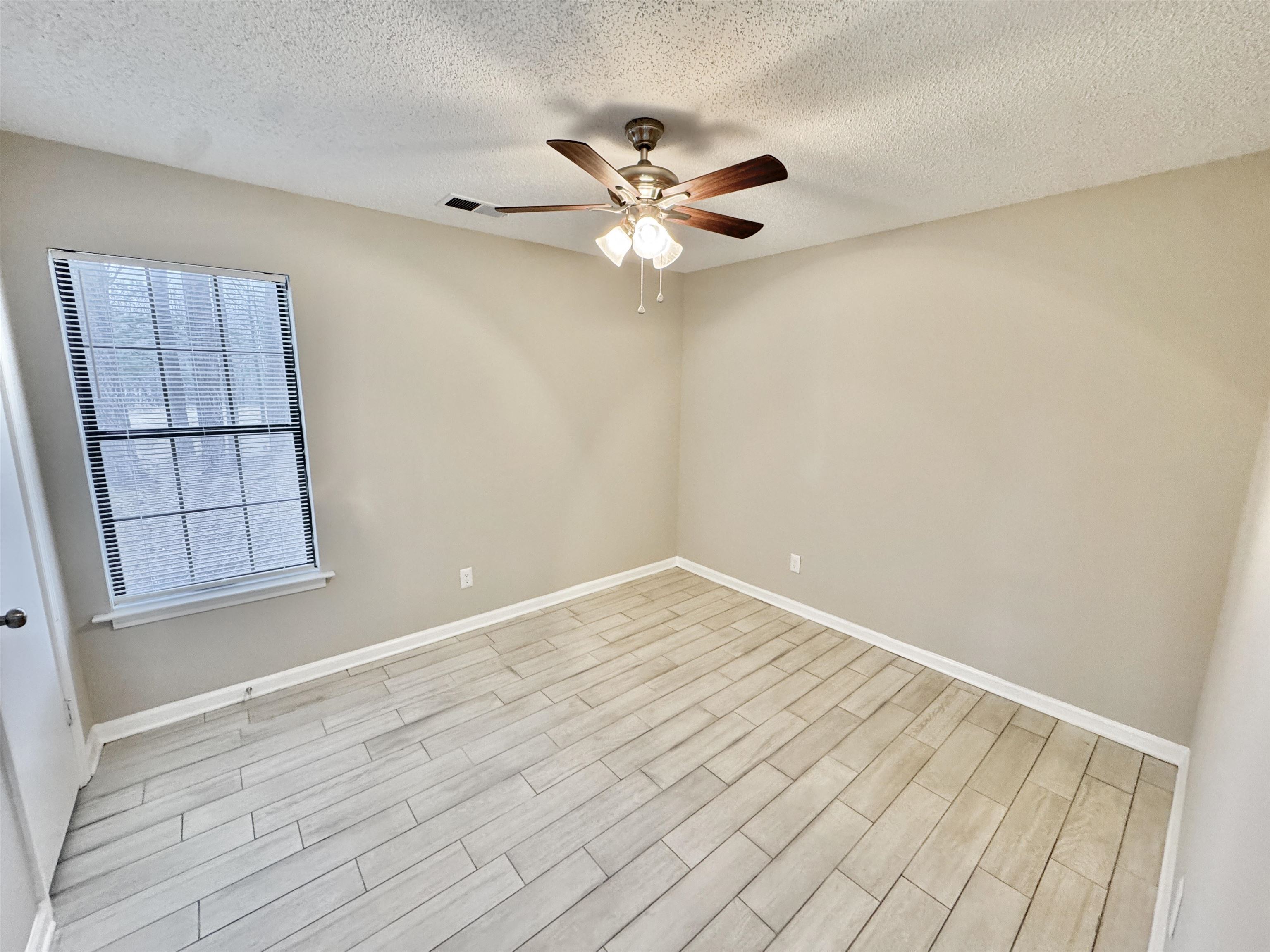 6400 Kerrville Rosemark Road Millington, TN 38053 - Photo 23 of 36 Unfurnished room featuring wood tiled floors, a textured ceiling, and ceiling fan