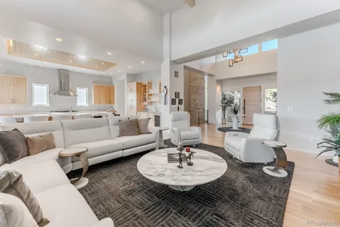 a living room with furniture and a dining table with wooden floor