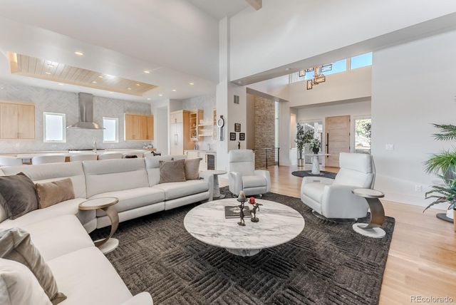 a living room with furniture and a dining table with wooden floor