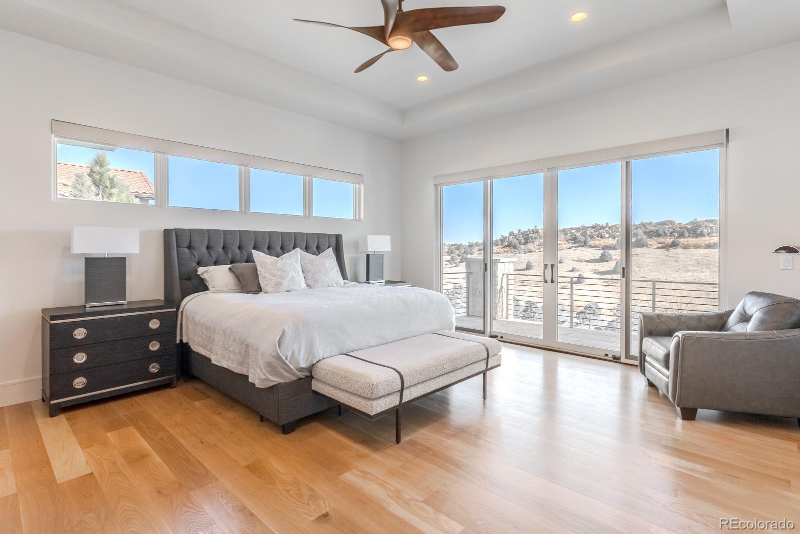 7572 Raphael Lane Littleton, CO 80125 - Photo 18 of 50 a spacious bedroom with a bed a couch and a flat tv screen
