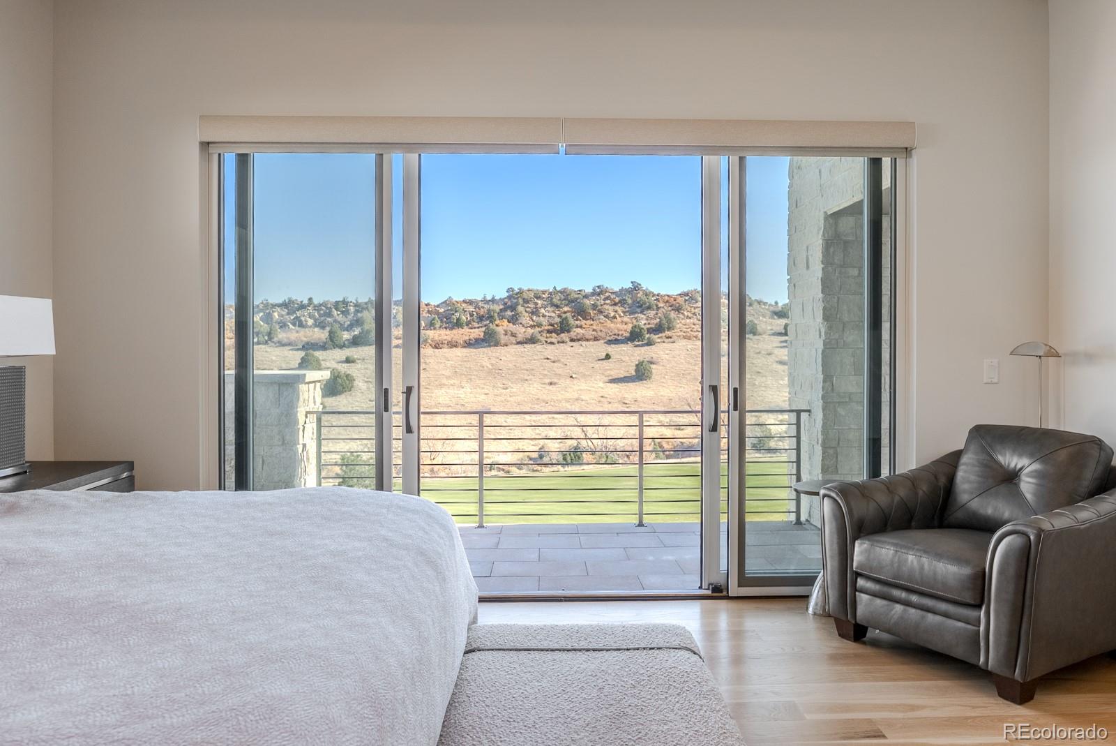 7572 Raphael Lane Littleton, CO 80125 - Photo 19 of 50 a bedroom with a bed and glass window