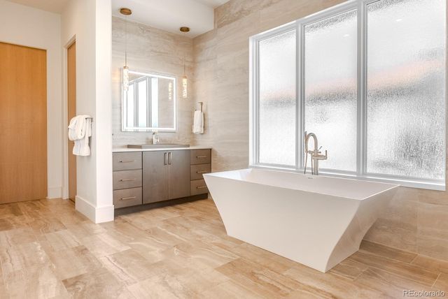a large bathroom with a tub sink and mirror