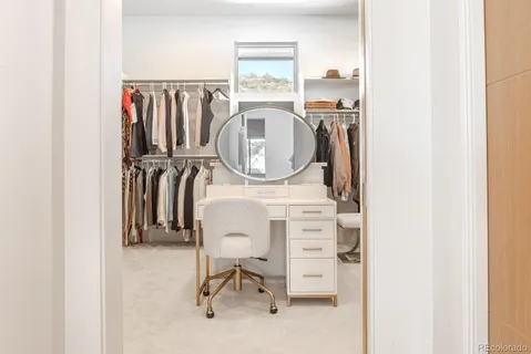 a view of walk in closet with clothes and shoes