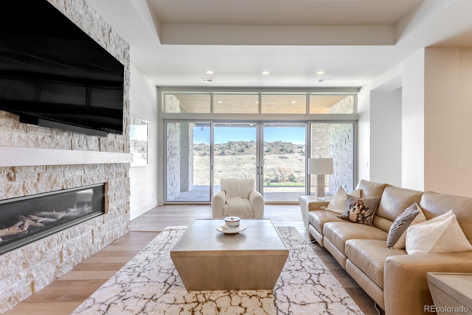 7572 Raphael Lane Littleton, CO 80125 - Photo 30 of 50 a living room with fireplace furniture and a flat screen tv