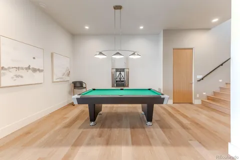 a room with pool table windows and wooden floor
