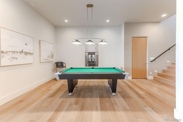 a room with pool table windows and wooden floor