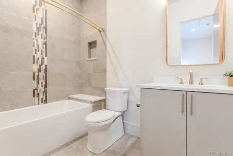a bathroom with a toilet a sink a mirror and bathtub
