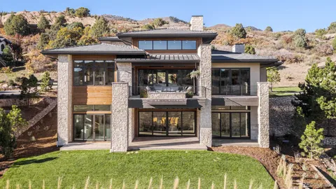 a view of a house with a big yard and large trees