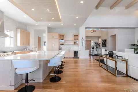 a large white kitchen with lots of counter space and stainless steel appliances