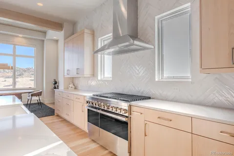a kitchen with stainless steel appliances granite countertop a sink stove and cabinets