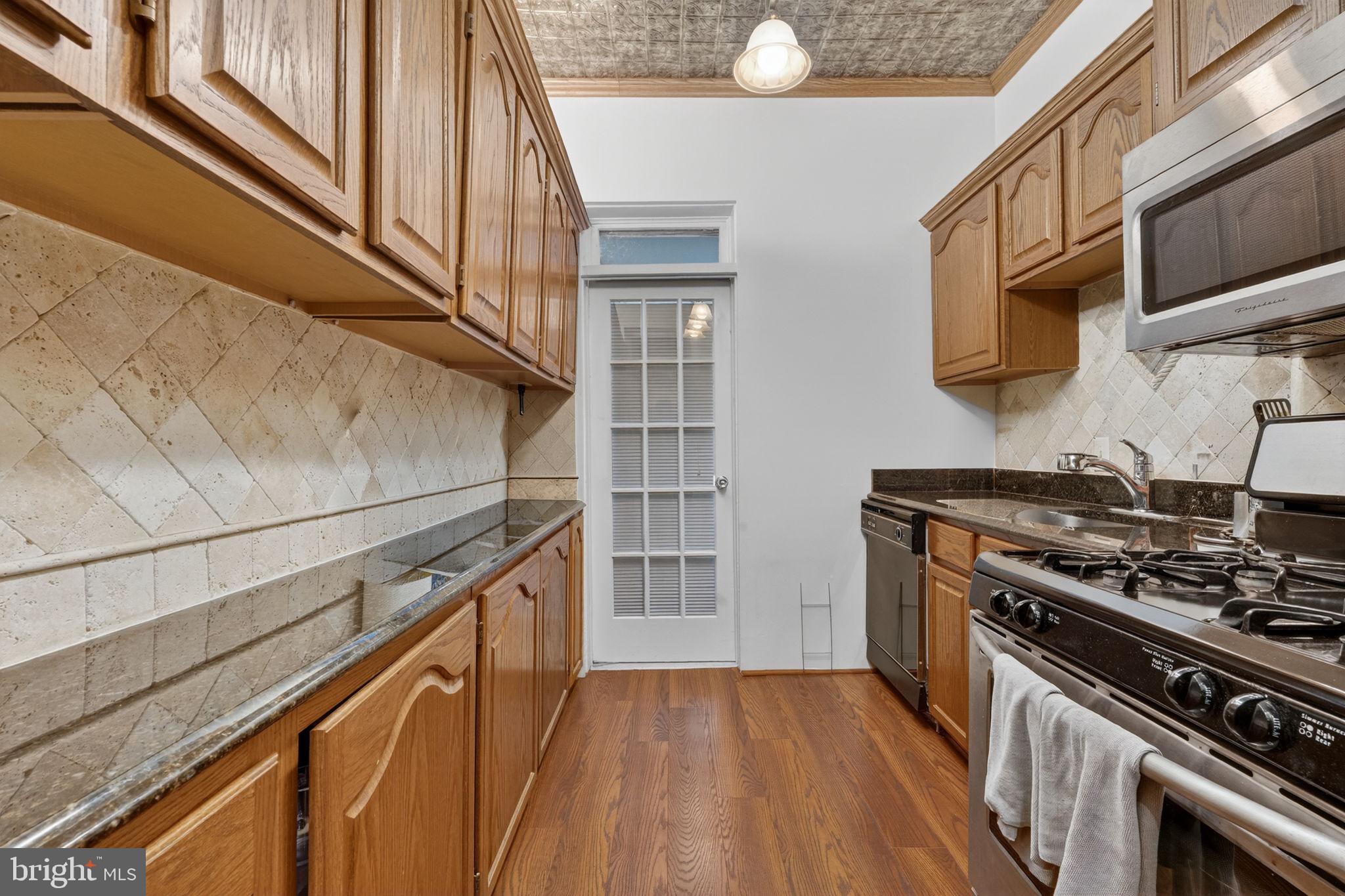 15 3rd Street Northeast, Unit 2 Washington, DC 20002 - Photo 17 of 32 a kitchen with stainless steel appliances granite countertop a stove and a microwave