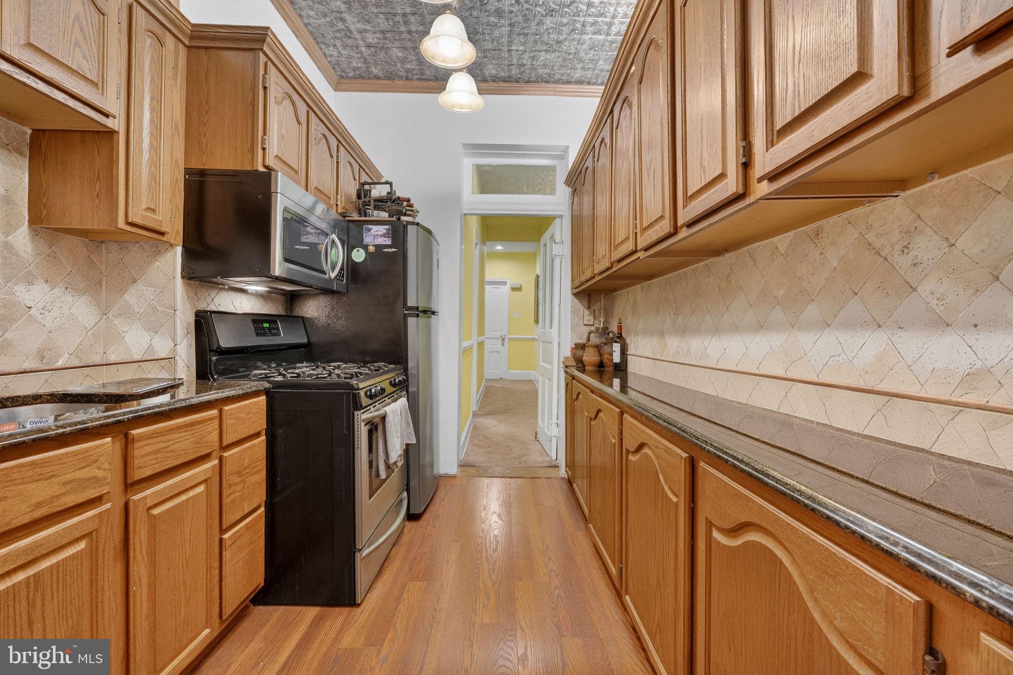 15 3rd Street Northeast, Unit 2 Washington, DC 20002 - Photo 18 of 32 a kitchen with stainless steel appliances granite countertop a refrigerator a stove and a wooden floors