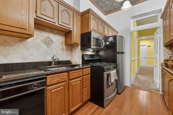 a kitchen with stainless steel appliances granite countertop a stove a sink and a refrigerator