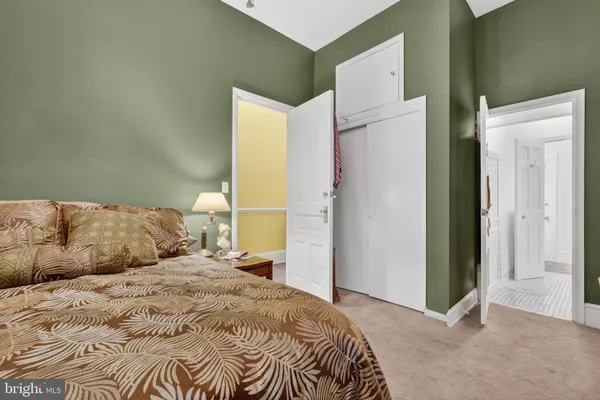 a bedroom with a bed and a refrigerator