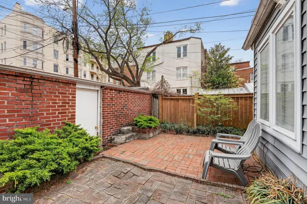 a view of a chair and table in backyard of the house