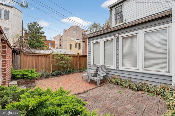 a backyard of a house with outdoor seating and plants