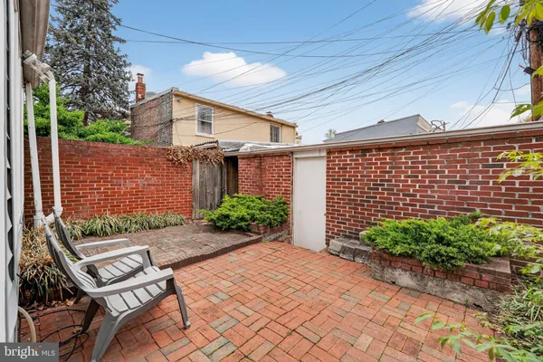 a backyard of a house with plants and wooden fence